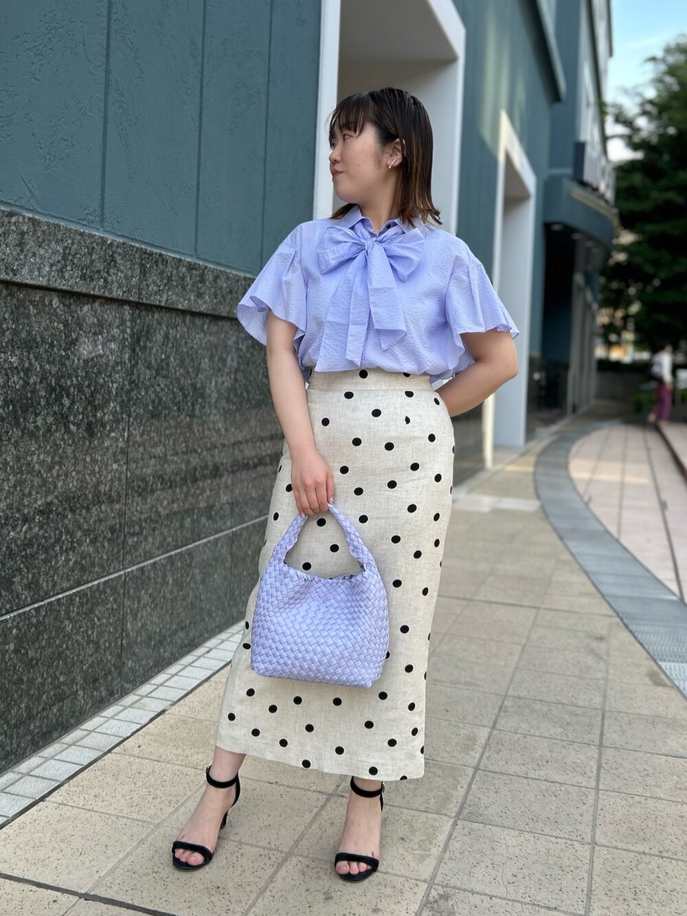 パープル系のシャツ/ブラウス、ベージュ系のスカート、パープル系のショルダーバッグを着用したレディースの春コーディネートの10枚目の写真
