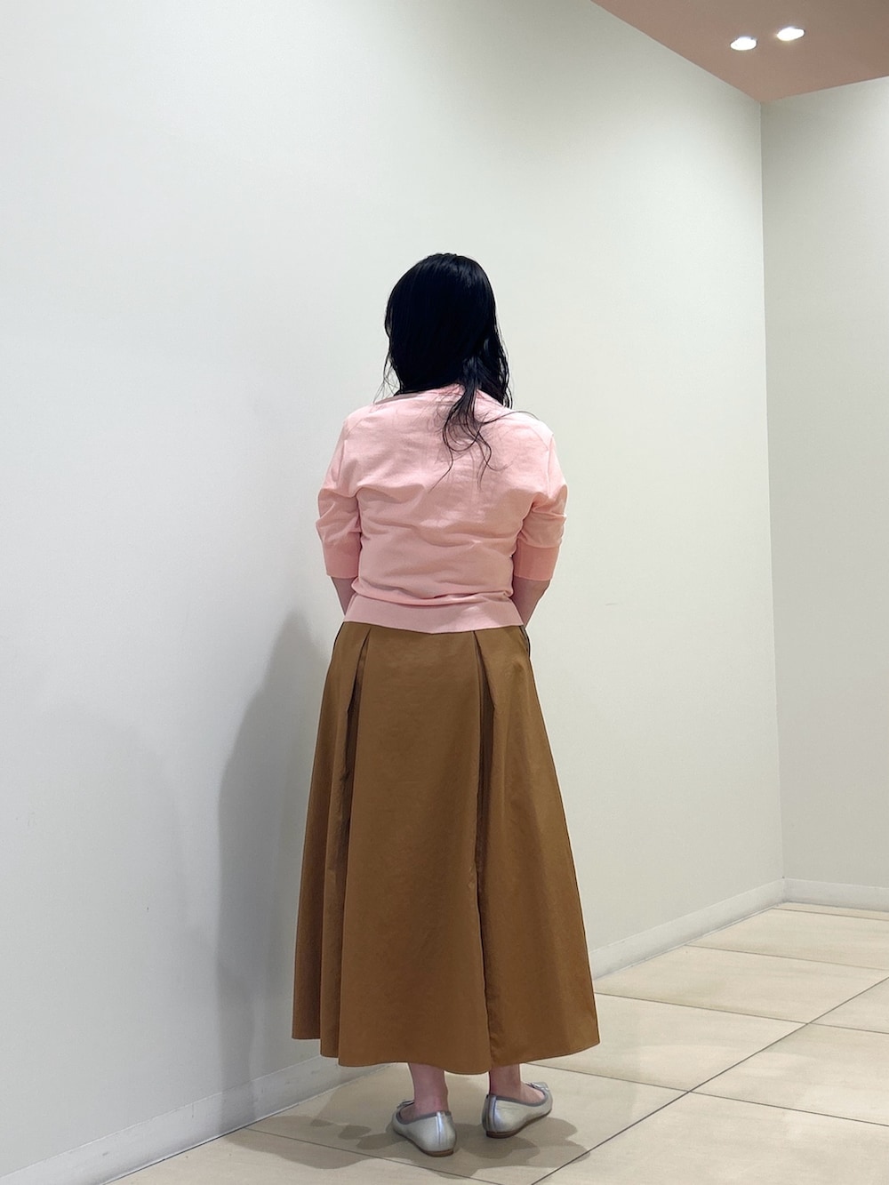 ピンク系のカーディガン/ボレロ、イエロー系のスカート、ブラウン系のボストンバッグを着用したレディースの夏コーディネートの3枚目の写真