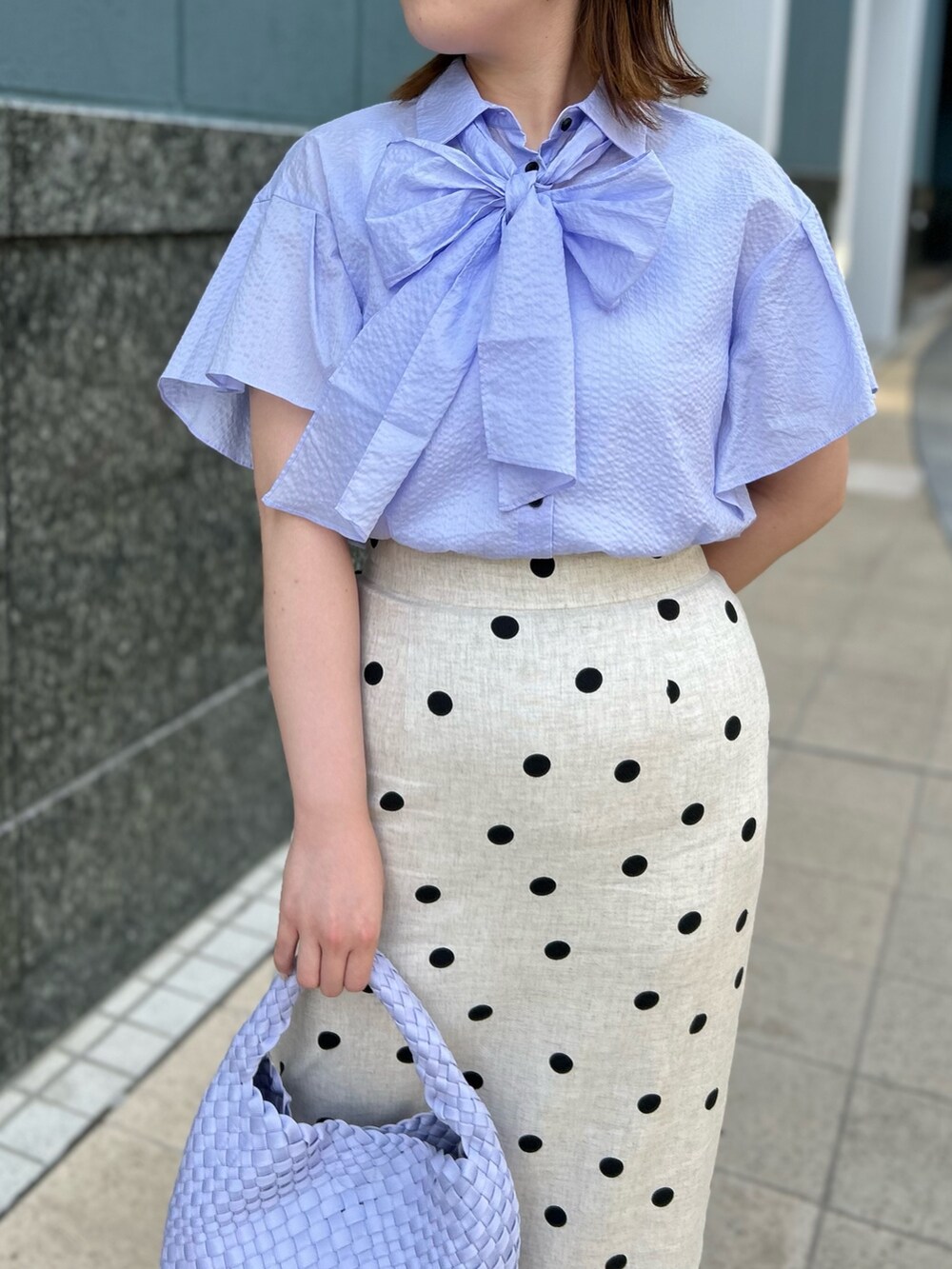 パープル系のシャツ/ブラウス、ベージュ系のスカート、パープル系のショルダーバッグを着用したレディースの春コーディネートの8枚目の写真