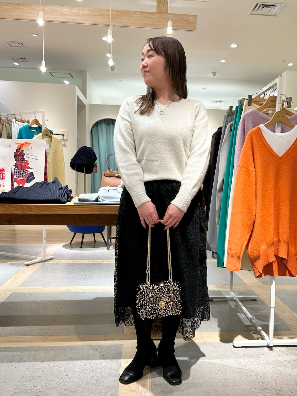 ホワイト系のニット/セーター、ブラック系のスカート、その他のショルダーバッグを着用したレディースの冬コーディネートの10枚目の写真