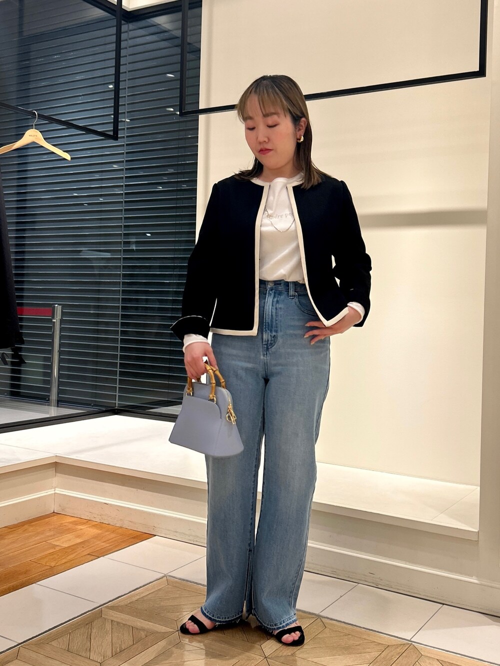 ブラック系のノーカラージャケット、ホワイト系のTシャツ/カットソー、ブルー系のデニムパンツを着用したレディースの冬コーディネートの10枚目の写真