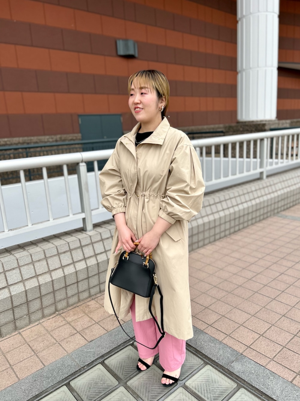 ベージュ系のその他アウター、ブラック系のニット/セーター、ピンク系のチノパンツを着用したレディースの春コーディネートの9枚目の写真