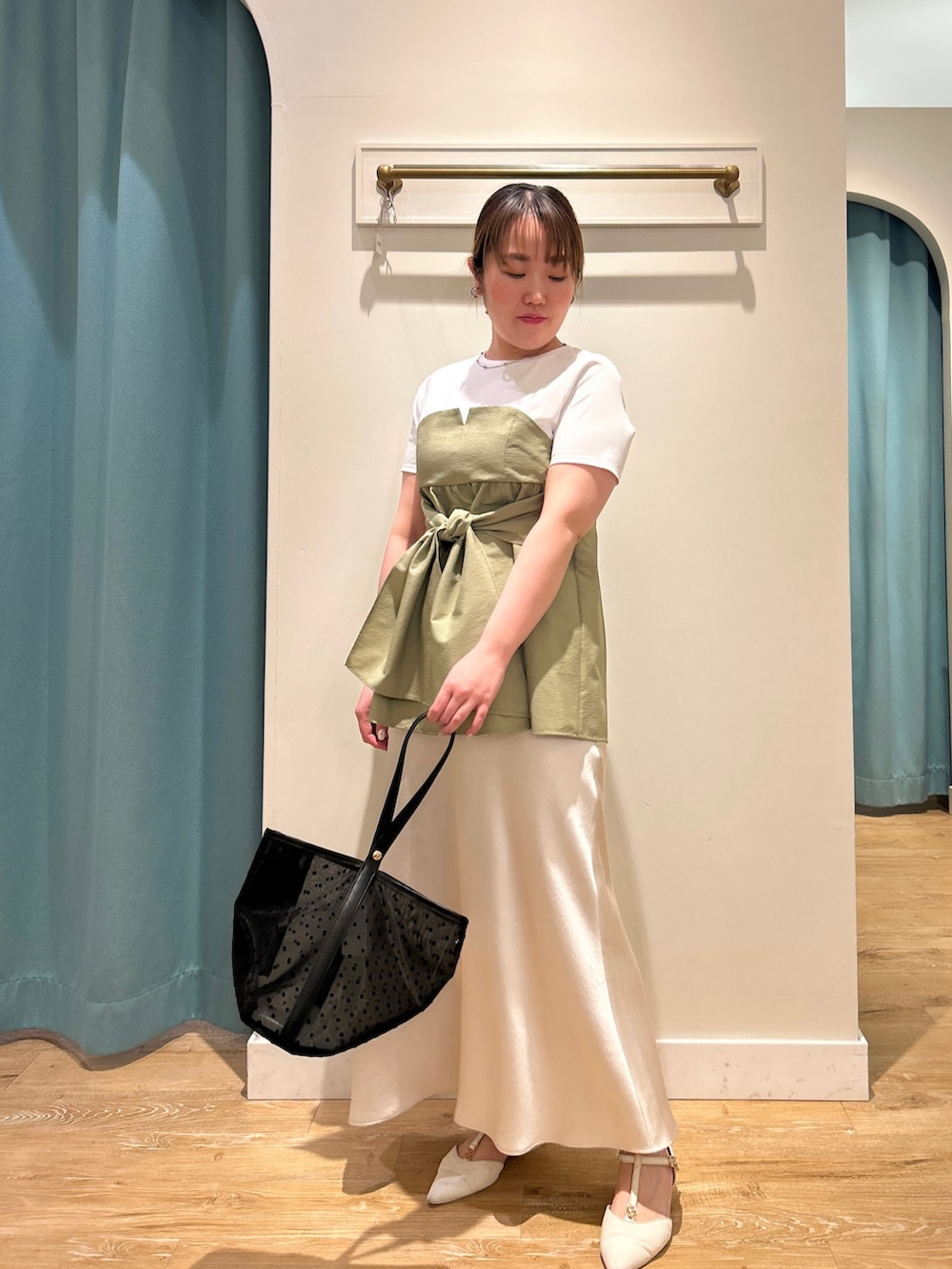 グリーン系のTシャツ/カットソー、ホワイト系のスカート、ブラック系のトートバッグを着用したレディースの夏コーディネートの5枚目の写真