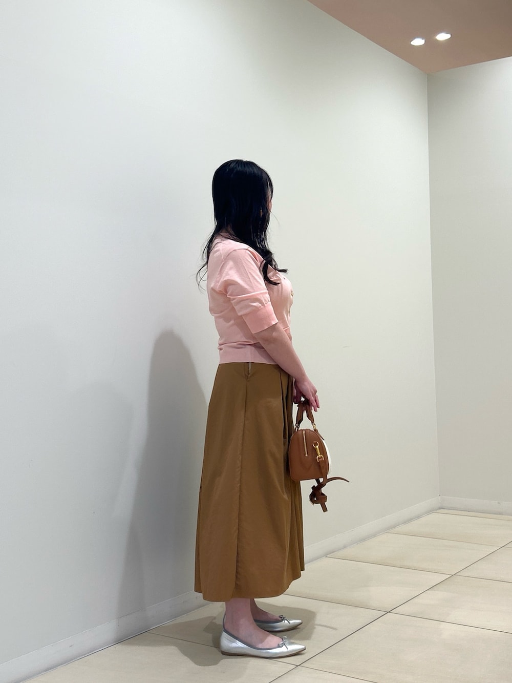ピンク系のカーディガン/ボレロ、イエロー系のスカート、ブラウン系のボストンバッグを着用したレディースの夏コーディネートの4枚目の写真