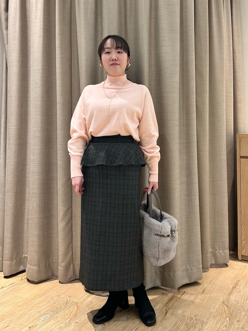 ピンク系のニット/セーター、ブラック系のスカート、ベージュ系のトートバッグを着用したレディースの冬コーディネートの8枚目の写真