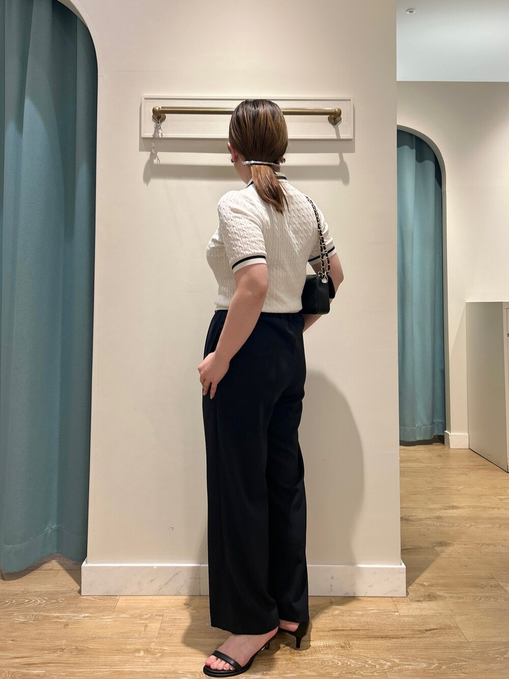 ホワイト系のニット/セーター、ブルー系のその他パンツ、ブラック系のショルダーバッグを着用したレディースの夏コーディネートの4枚目の写真