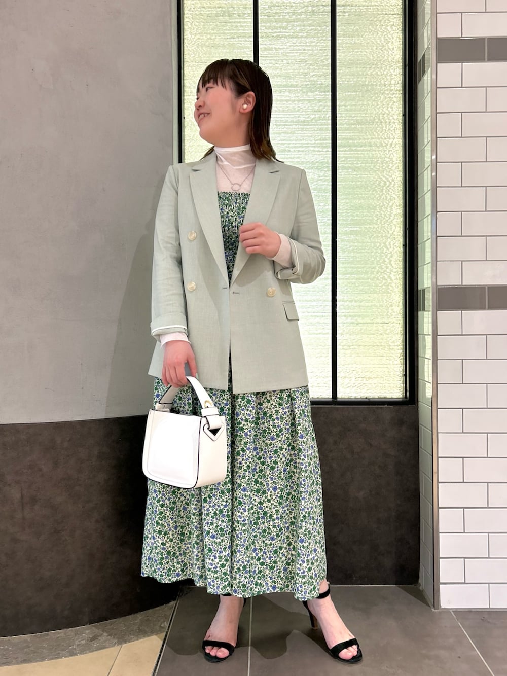 グリーン系のワンピース、ホワイト系のTシャツ/カットソー、グリーン系のテーラードジャケットを着用したレディースの春コーディネートの2枚目の写真