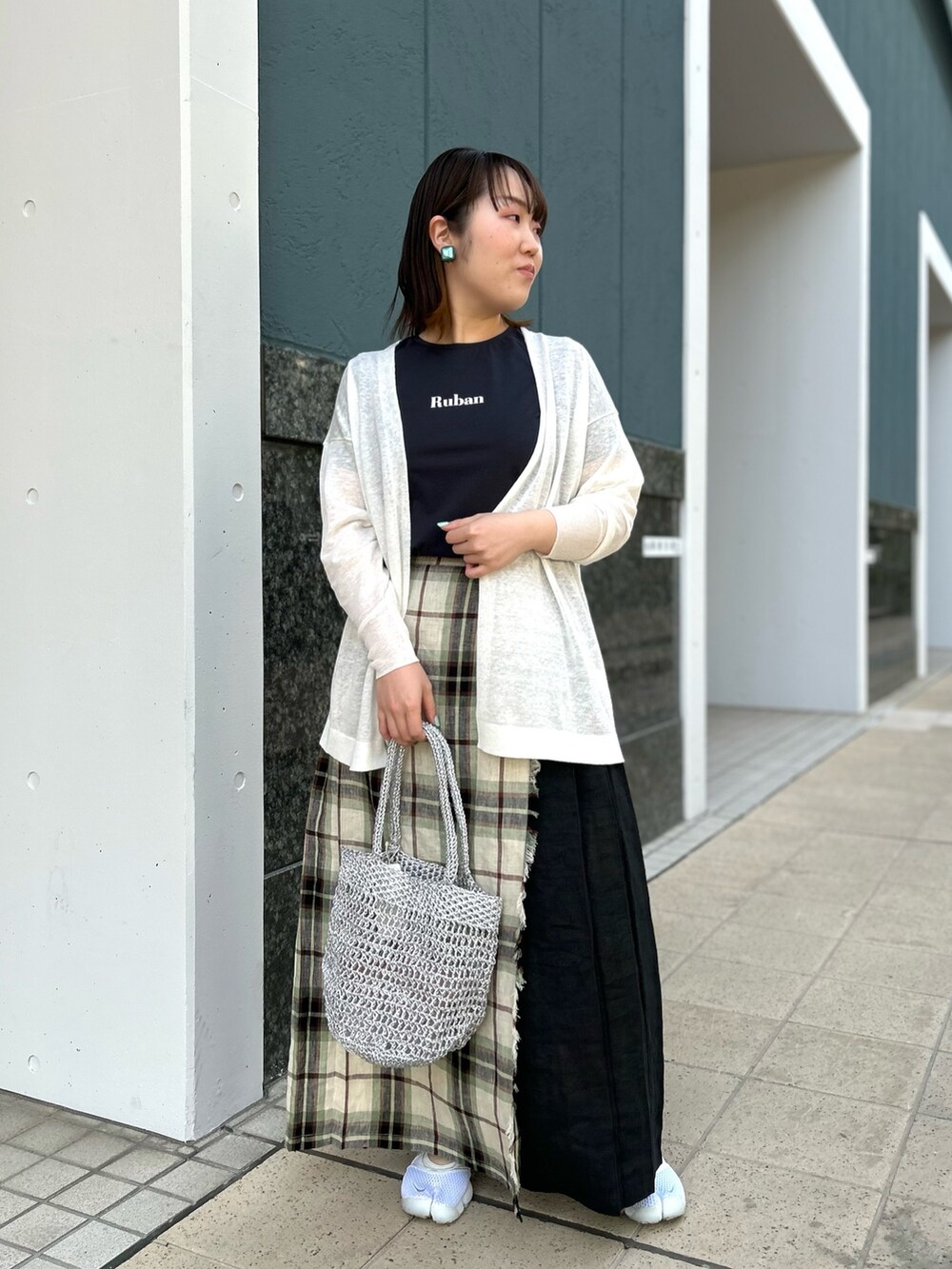 ホワイト系のカーディガン/ボレロ、ブラック系のスカート、シルバー系のバックパック/リュックを着用したレディースの春コーディネートの3枚目の写真
