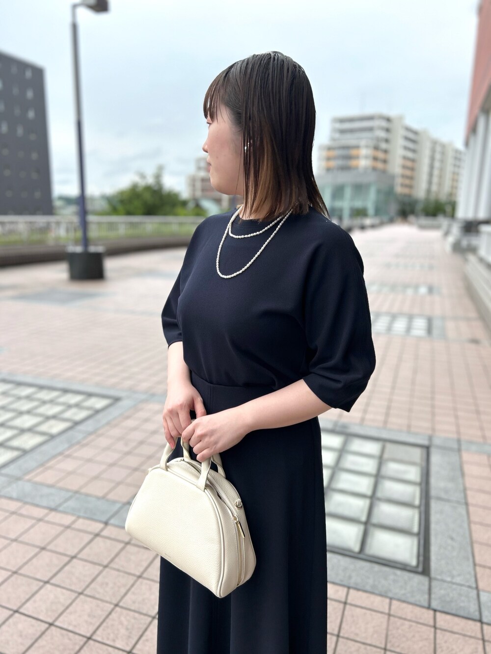 ブルー系のTシャツ/カットソー、ブルー系のスカート、ホワイト系のボストンバッグを着用したレディースの春コーディネートの7枚目の写真