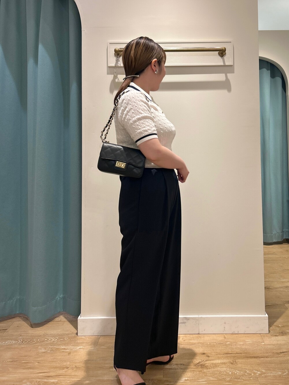 ホワイト系のニット/セーター、ブルー系のその他パンツ、ブラック系のショルダーバッグを着用したレディースの夏コーディネートの6枚目の写真