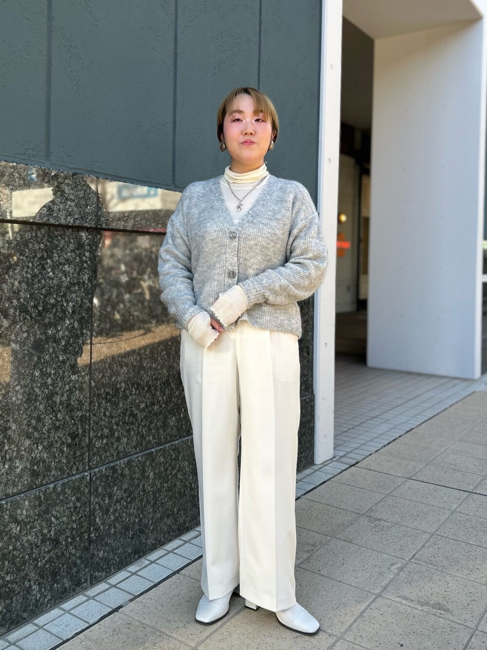 グレー系のカーディガン/ボレロ、ホワイト系のTシャツ/カットソー、ホワイト系のその他パンツを着用したレディースの冬コーディネートの3枚目の写真