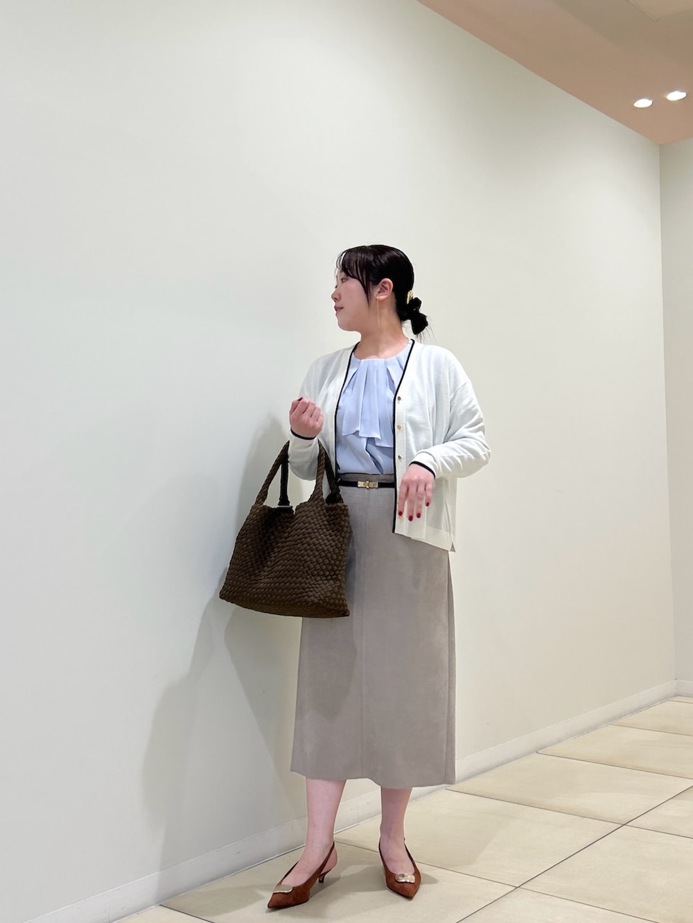 ホワイト系のカーディガン/ボレロ、ブルー系のシャツ/ブラウス、ベージュ系のスカートを着用したレディースの秋コーディネートの8枚目の写真