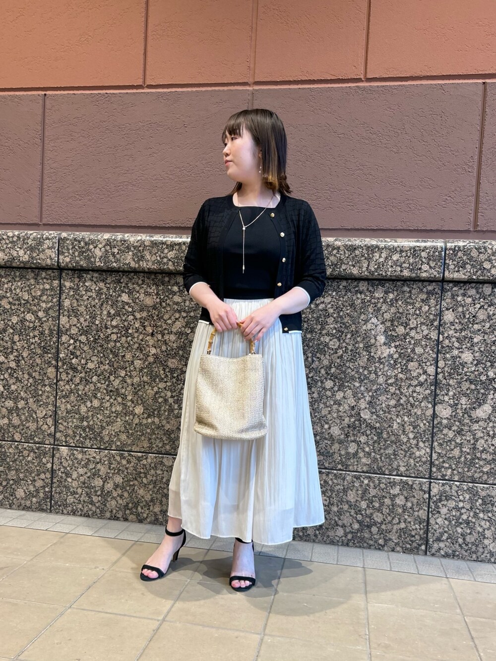 ブラック系のニット/セーター、ブラック系のカーディガン/ボレロ、ベージュ系のトートバッグを着用したレディースの春コーディネートの8枚目の写真