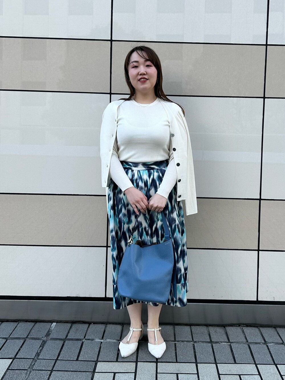 ホワイト系のカーディガン/ボレロ、ホワイト系のニット/セーター、ブルー系のスカートを着用したレディースの秋コーディネートの10枚目の写真