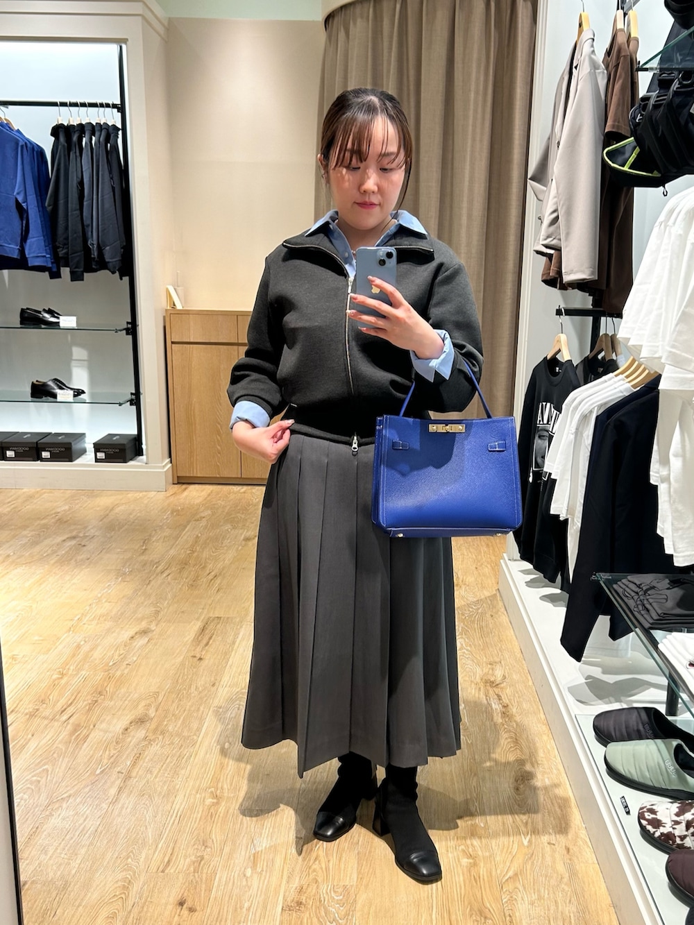 グレー系のブルゾン、ブルー系のシャツ/ブラウス、グレー系のスカートを着用したレディースの秋コーディネートの10枚目の写真