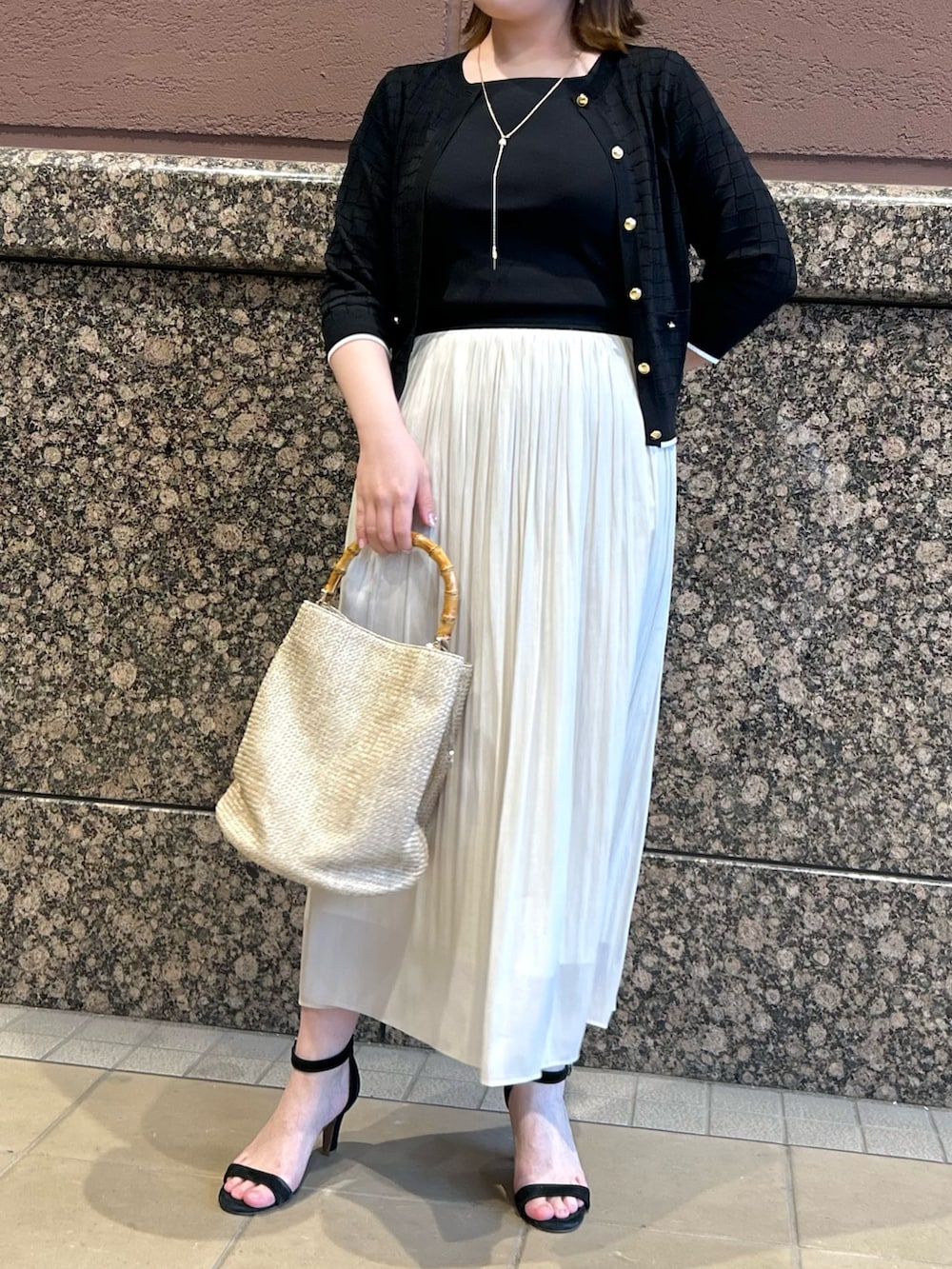 ブラック系のニット/セーター、ブラック系のカーディガン/ボレロ、ベージュ系のトートバッグを着用したレディースの春コーディネートの6枚目の写真