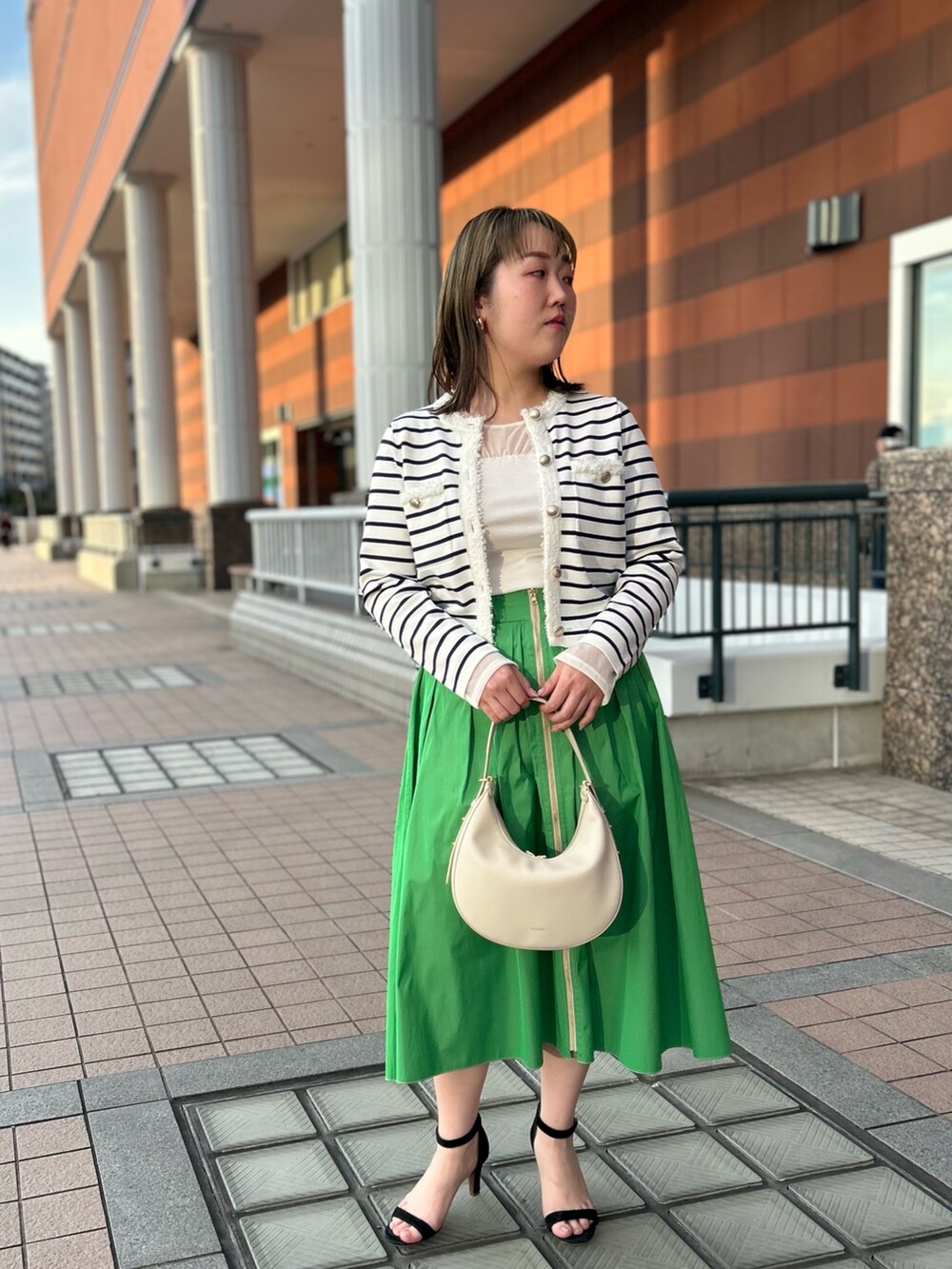 ホワイト系のカーディガン/ボレロ、グリーン系のスカート、ホワイト系のTシャツ/カットソーを着用したレディースの冬コーディネートの9枚目の写真