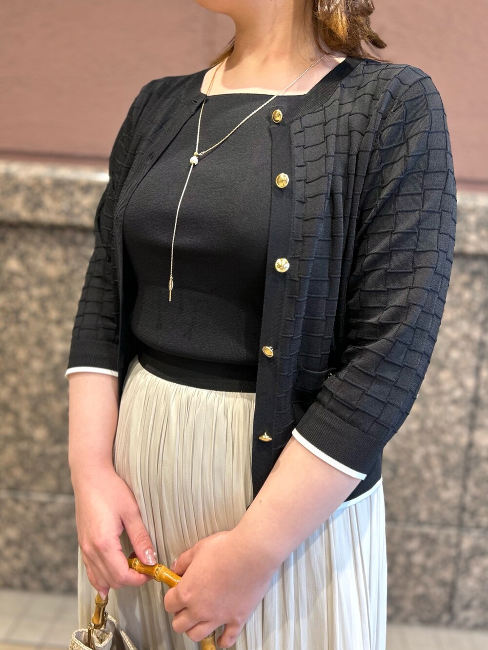 ブラック系のニット/セーター、ブラック系のカーディガン/ボレロ、ベージュ系のトートバッグを着用したレディースの春コーディネートの9枚目の写真