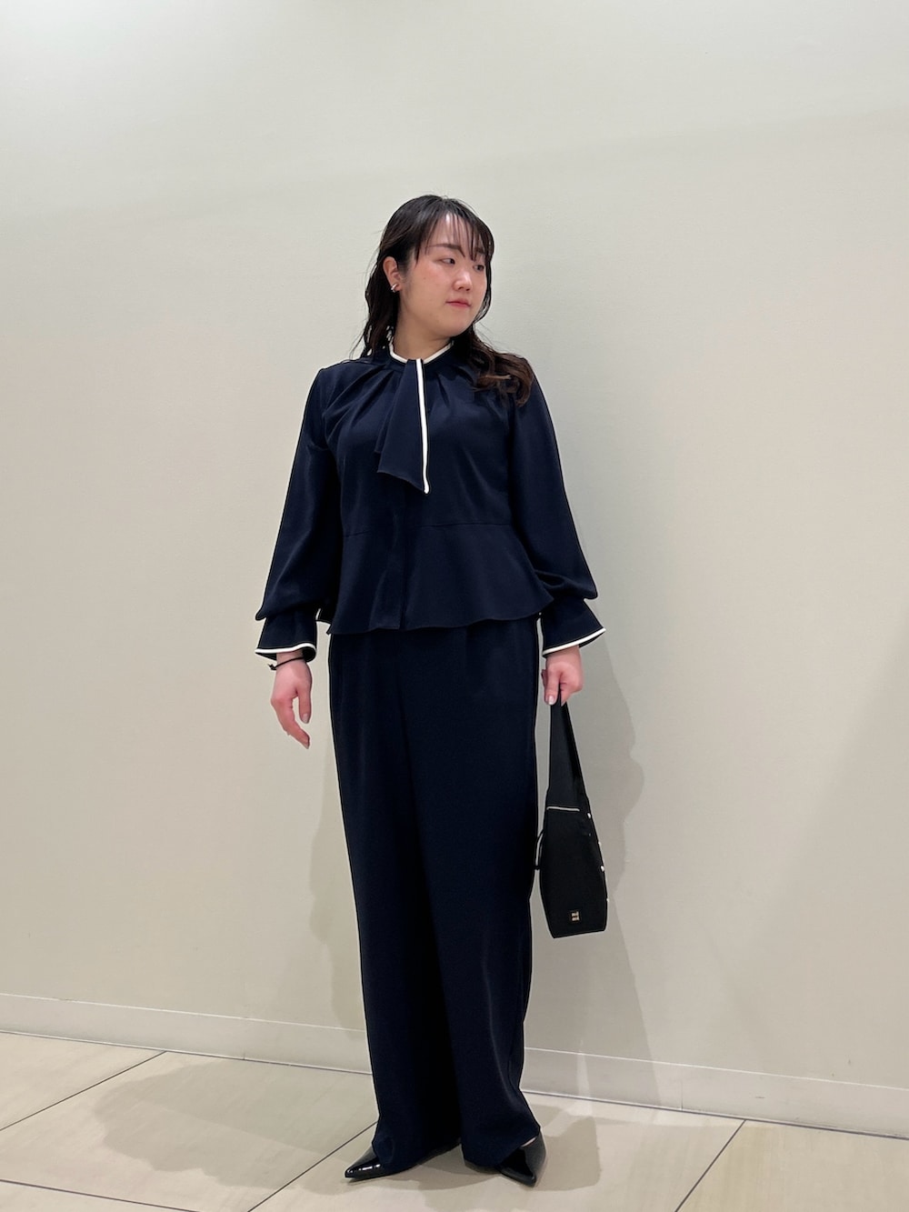 ブルー系のシャツ/ブラウス、ブルー系のその他パンツ、ブラック系のハンドバッグを着用したレディースの春コーディネートの5枚目の写真