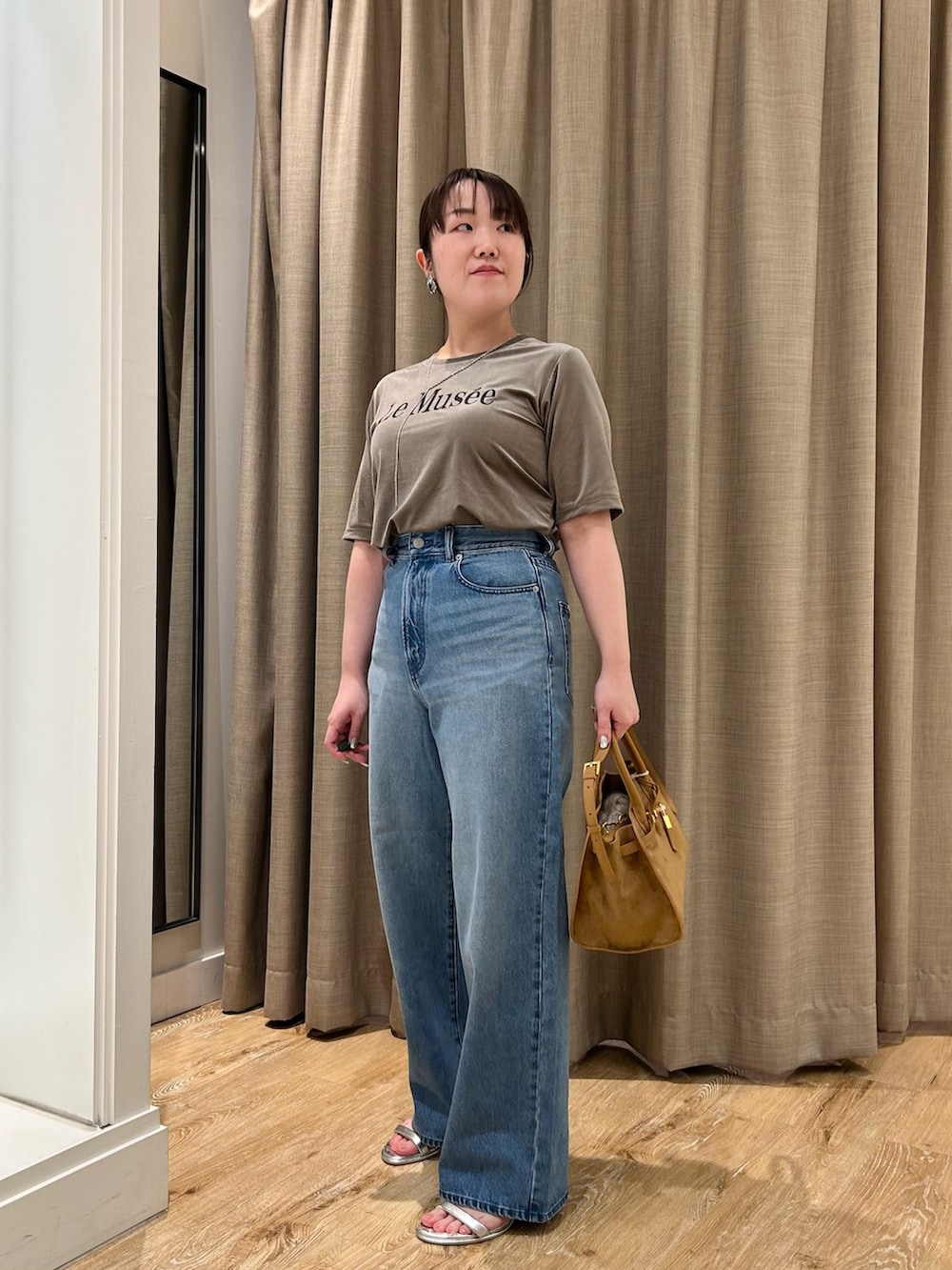 グリーン系のTシャツ/カットソー、ブルー系のデニムパンツ、イエロー系のトートバッグを着用したレディースの秋コーディネートの10枚目の写真