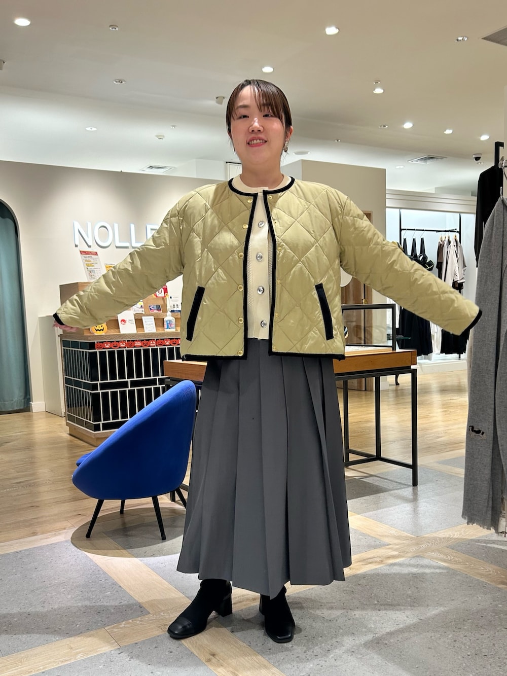 ベージュ系のダウンジャケット/コート、ホワイト系のカーディガン/ボレロ、グレー系のスカートを着用したレディースの秋コーディネートの8枚目の写真