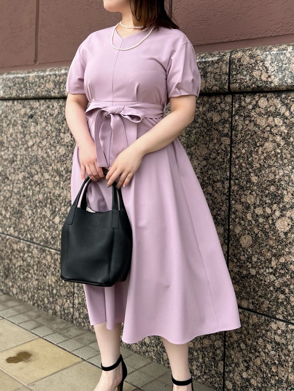 ピンク系のワンピース、ブラック系のトートバッグ、ホワイト系のネックレスを着用したレディースの夏コーディネートの3枚目の写真