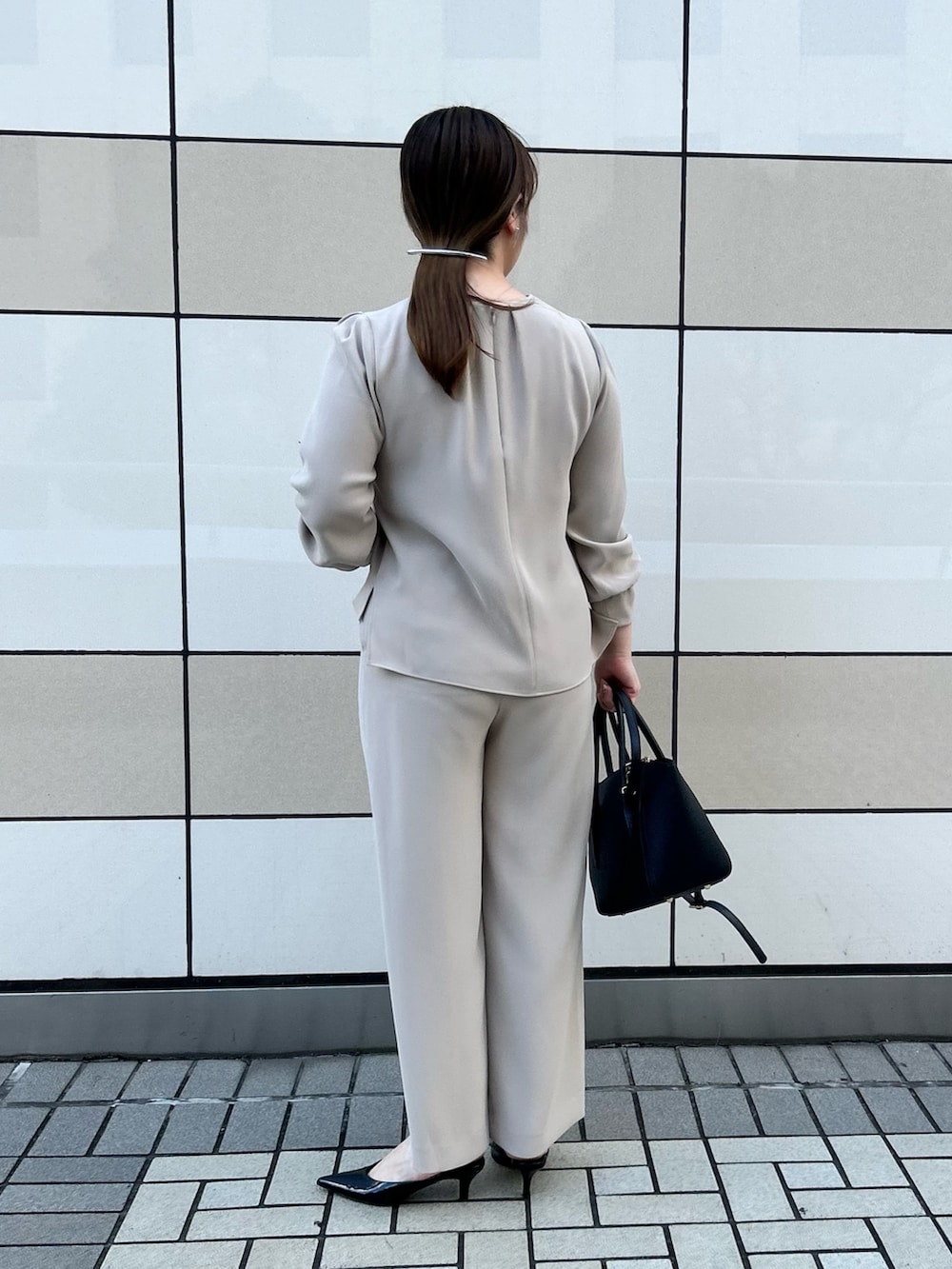 ベージュ系のシャツ/ブラウス、ベージュ系のその他パンツ、ブラック系のショルダーバッグを着用したレディースの秋コーディネートの3枚目の写真