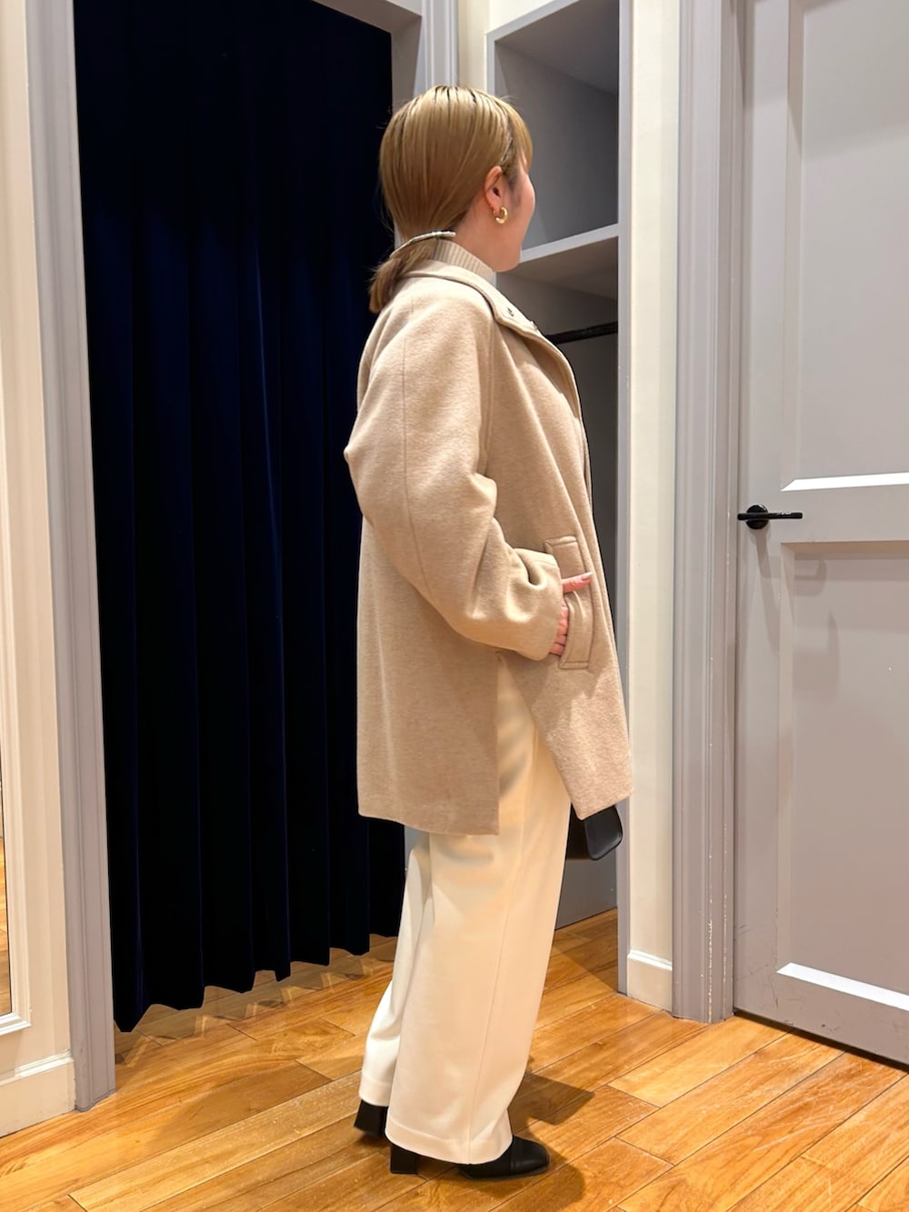 ベージュ系のその他アウター、ホワイト系のその他パンツ、ブルー系のニット/セーターを着用したレディースの冬コーディネートの6枚目の写真