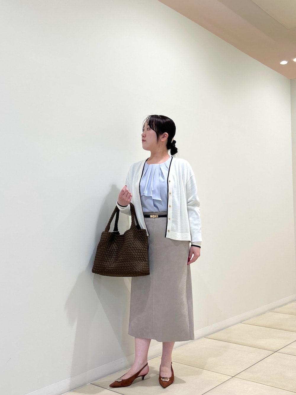 ホワイト系のカーディガン/ボレロ、ブルー系のシャツ/ブラウス、ベージュ系のスカートを着用したレディースの秋コーディネートの9枚目の写真