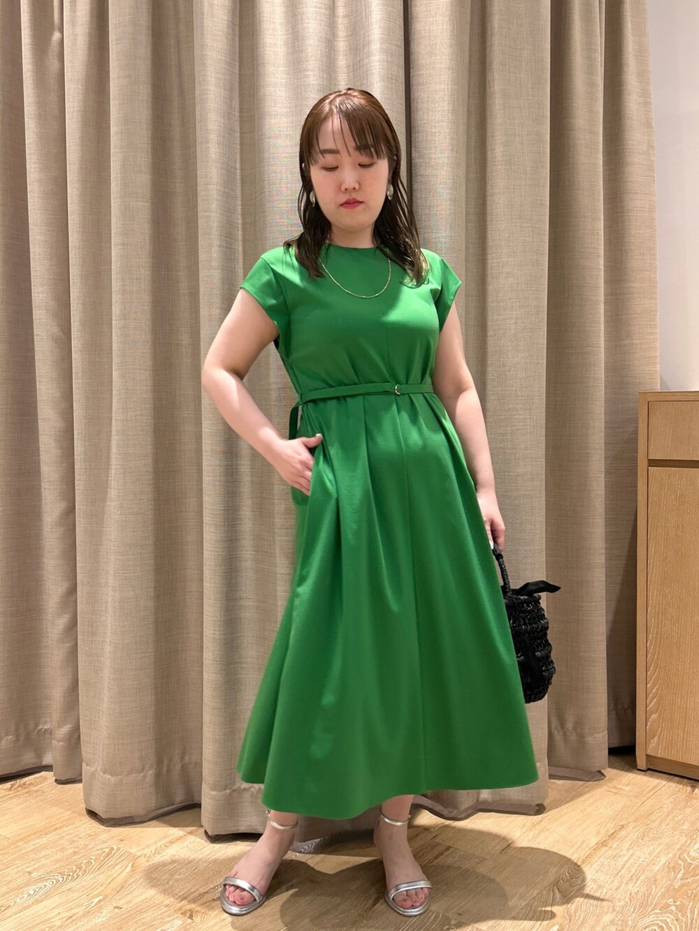 グリーン系のワンピース、ブラック系のかごバッグ、シルバー系のサンダルを着用したレディースの夏コーディネートの8枚目の写真