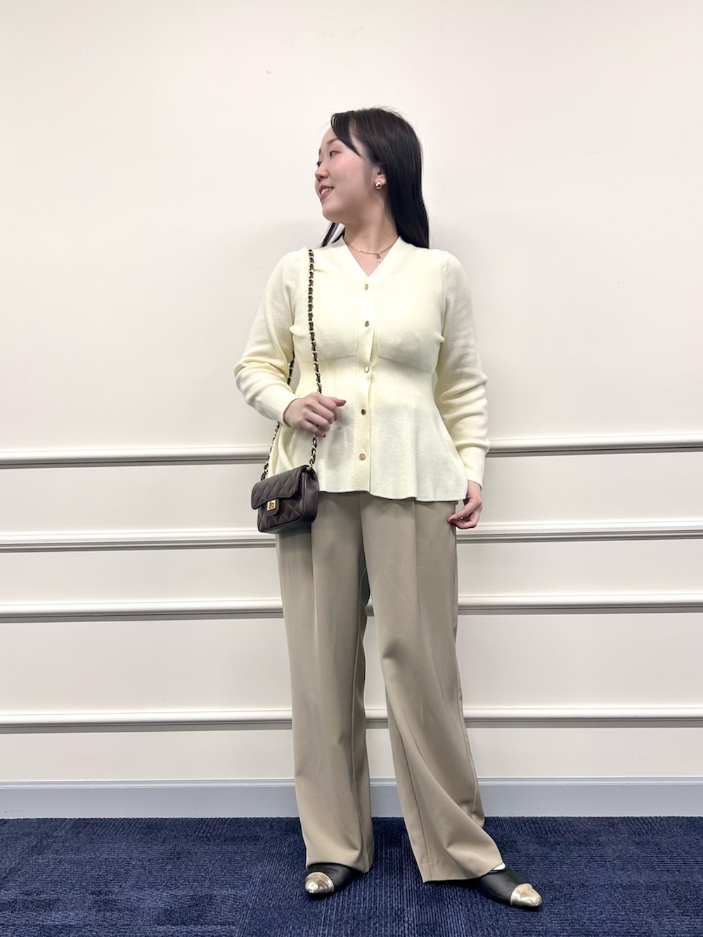 ホワイト系のカーディガン/ボレロ、ベージュ系のその他パンツ、ホワイト系のタンクトップを着用したレディースの秋コーディネートの6枚目の写真