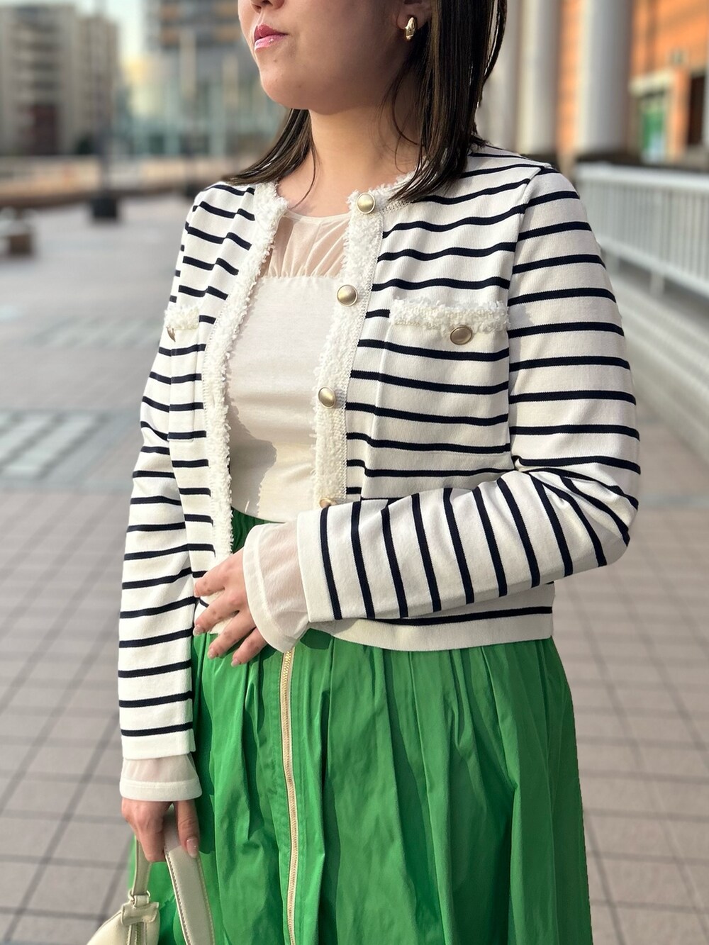 ホワイト系のカーディガン/ボレロ、グリーン系のスカート、ホワイト系のTシャツ/カットソーを着用したレディースの冬コーディネートの10枚目の写真