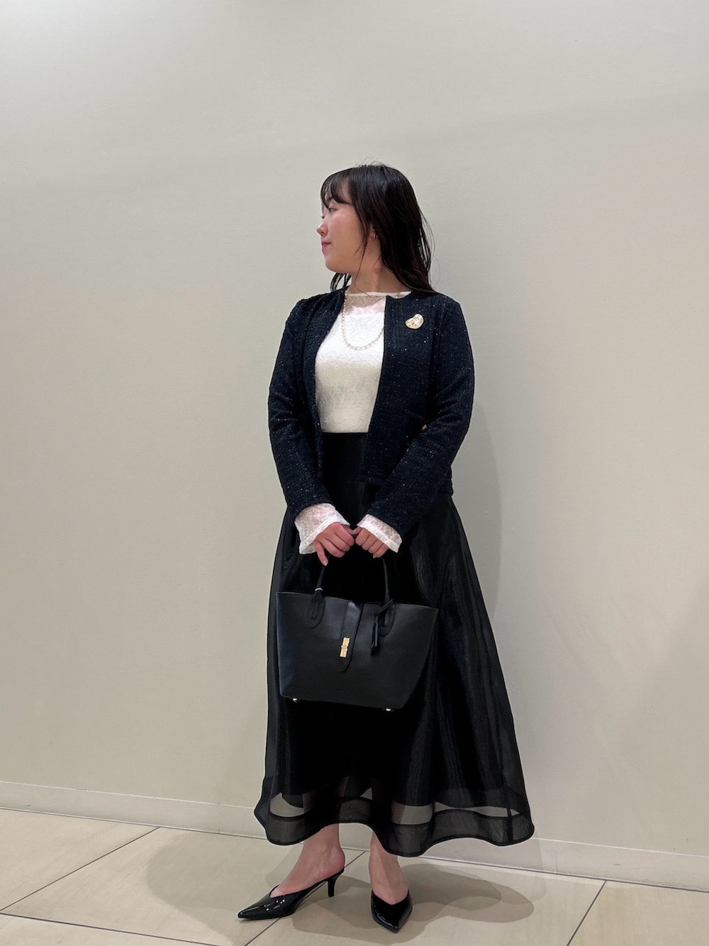 ブルー系のノーカラージャケット、ブラック系のスカート、ホワイト系のTシャツ/カットソーを着用したレディースの春コーディネートの8枚目の写真