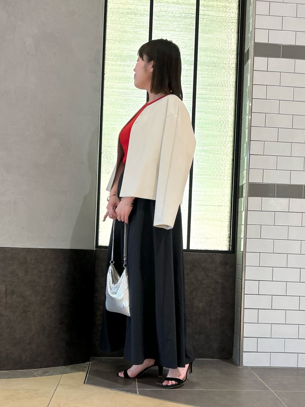 ベージュ系のブルゾン、レッド系のTシャツ/カットソー、ブラック系のスカートを着用したレディースの秋コーディネートの5枚目の写真