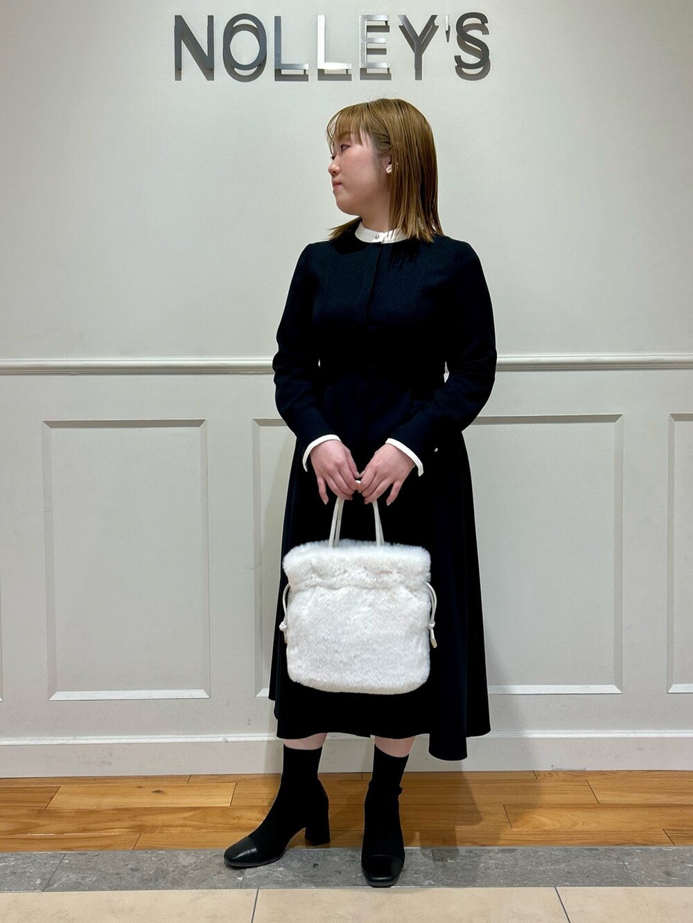 ブルー系のワンピース、ホワイト系のショルダーバッグ、ホワイト系のイヤリングを着用したレディースの冬コーディネートの8枚目の写真