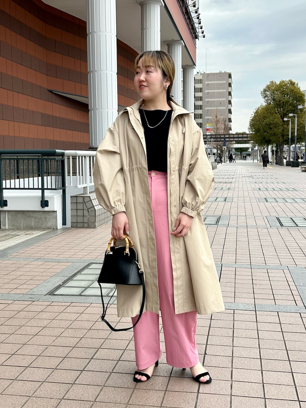 ベージュ系のその他アウター、ブラック系のニット/セーター、ピンク系のチノパンツを着用したレディースの春コーディネートの2枚目の写真