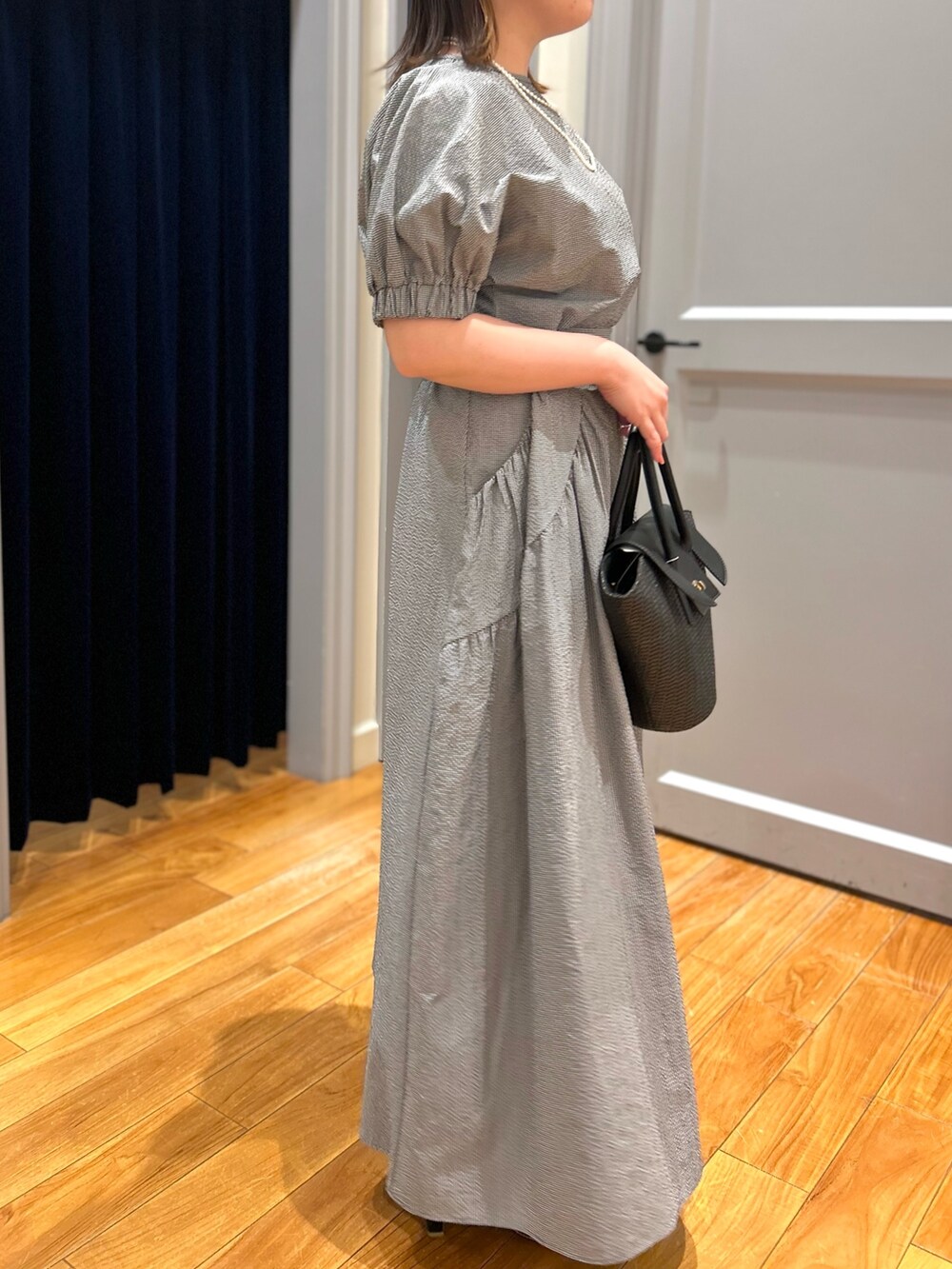 グレー系のシャツ/ブラウス、グレー系のスカート、ブラック系のかごバッグを着用したレディースの夏コーディネートの5枚目の写真