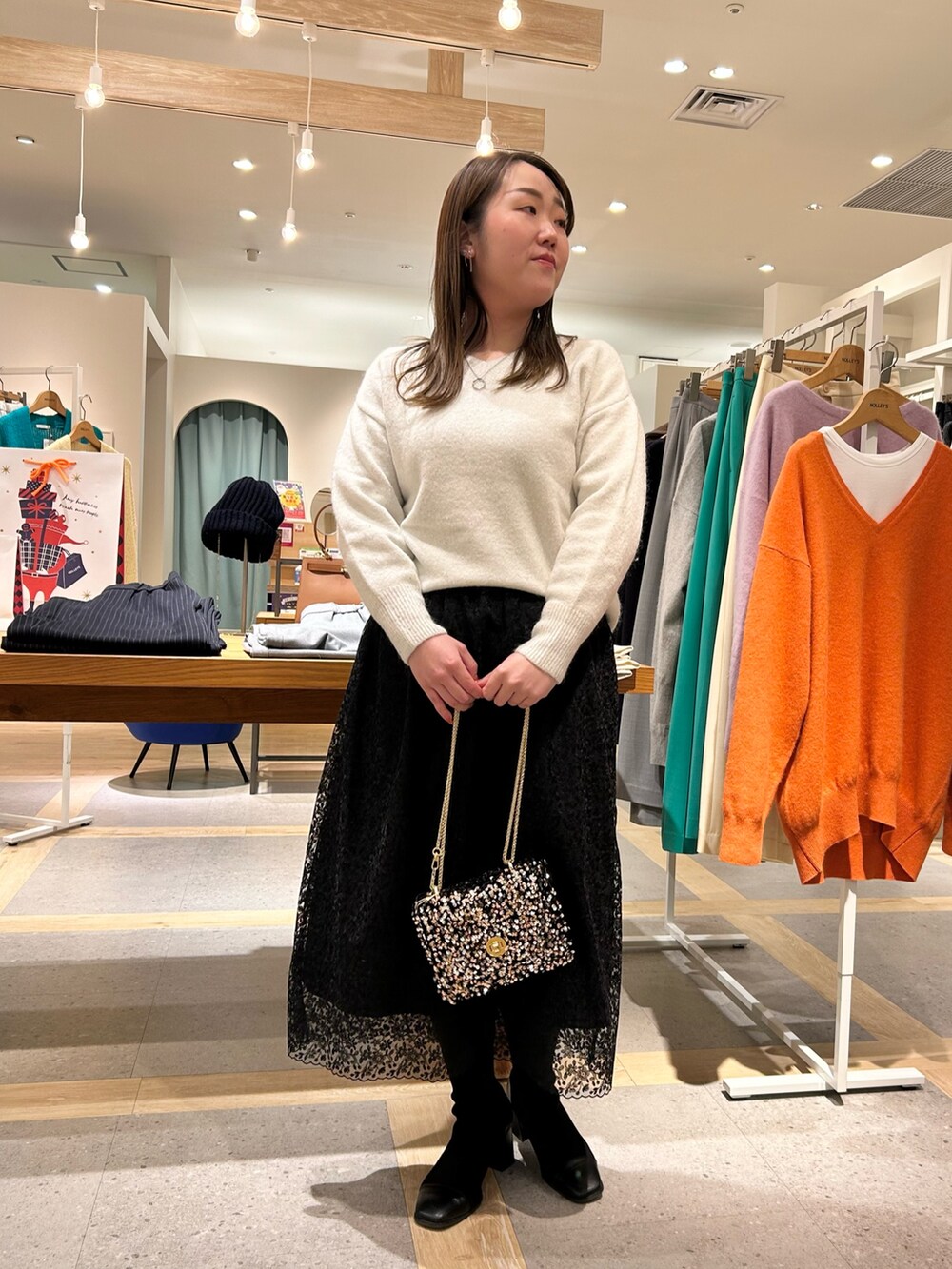 ホワイト系のニット/セーター、ブラック系のスカート、その他のショルダーバッグを着用したレディースの冬コーディネートの9枚目の写真
