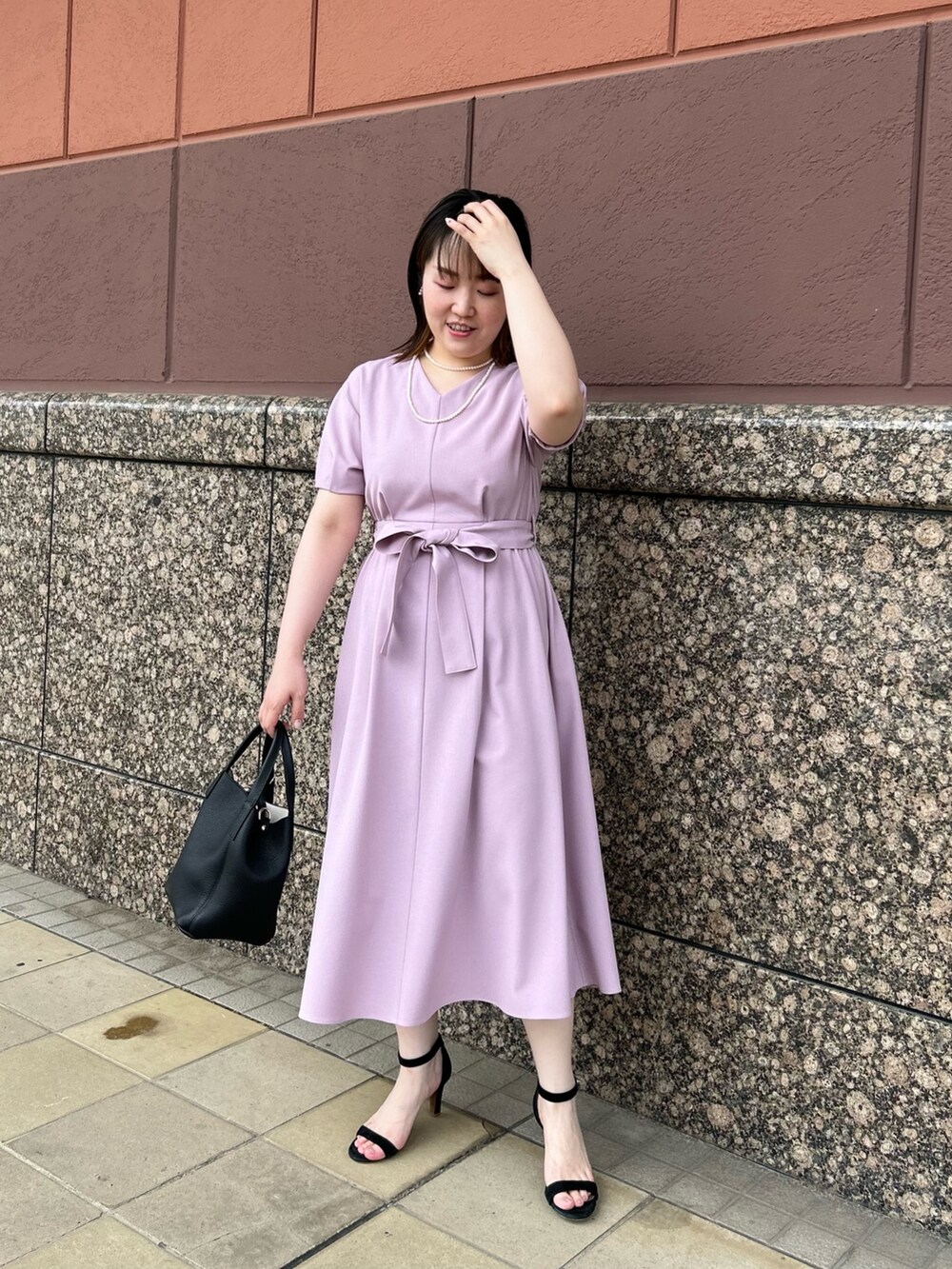 ピンク系のワンピース、ブラック系のトートバッグ、ホワイト系のネックレスを着用したレディースの夏コーディネートの9枚目の写真