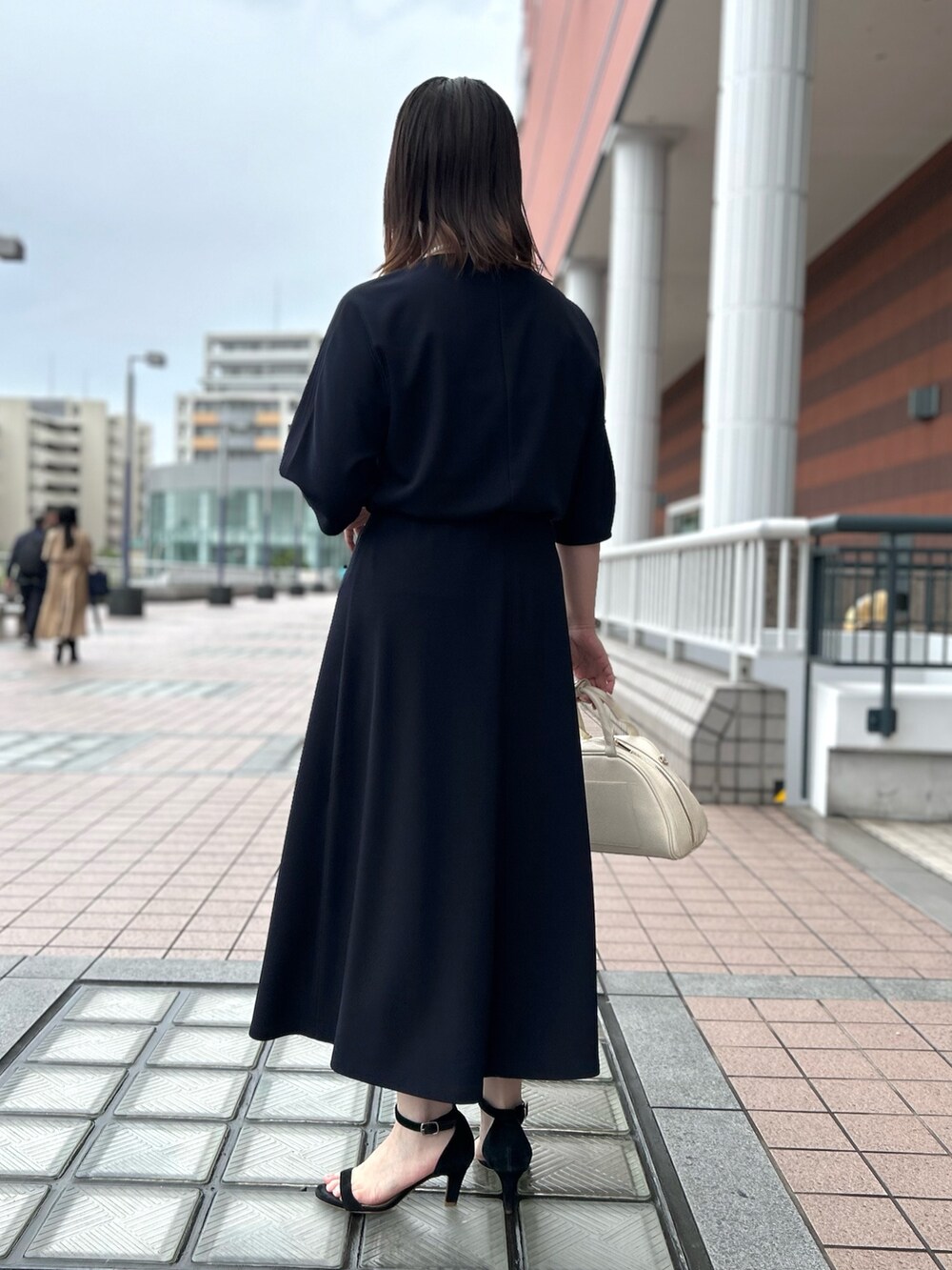 ブルー系のTシャツ/カットソー、ブルー系のスカート、ホワイト系のボストンバッグを着用したレディースの春コーディネートの4枚目の写真