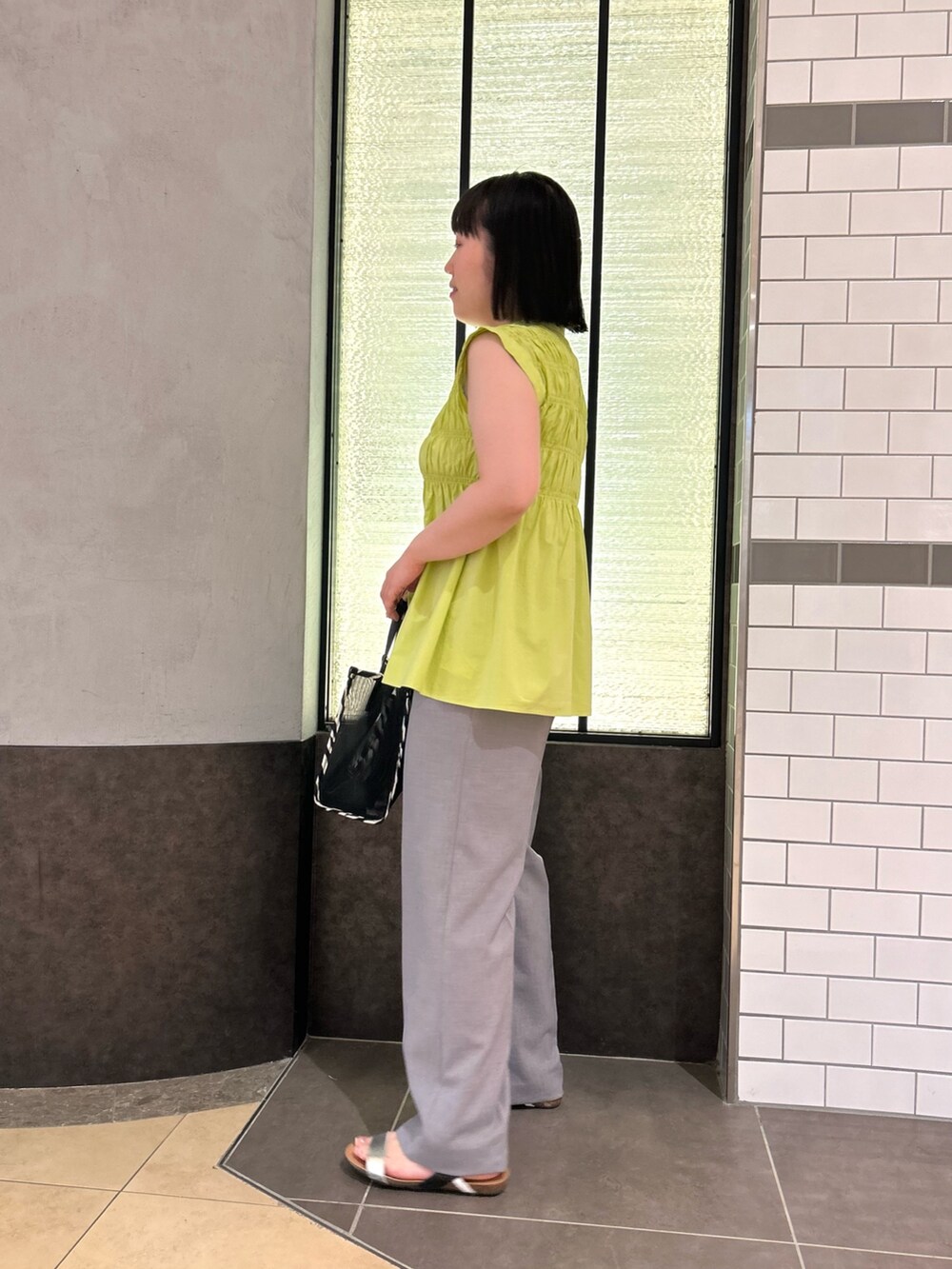 グリーン系のシャツ/ブラウス、ブラック系のトートバッグ、グレー系のその他パンツを着用したレディースの夏コーディネートの3枚目の写真