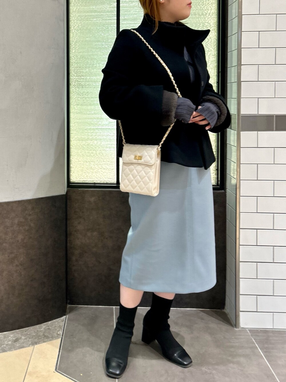 ブラック系のその他アウター、グレー系のニット/セーター、ブルー系のスカートを着用したレディースの冬コーディネートの7枚目の写真