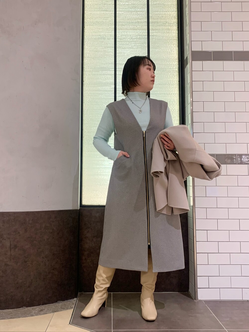 ベージュ系のその他アウター、グレー系のワンピース、グリーン系のニット/セーターを着用したレディースの冬コーディネートの7枚目の写真