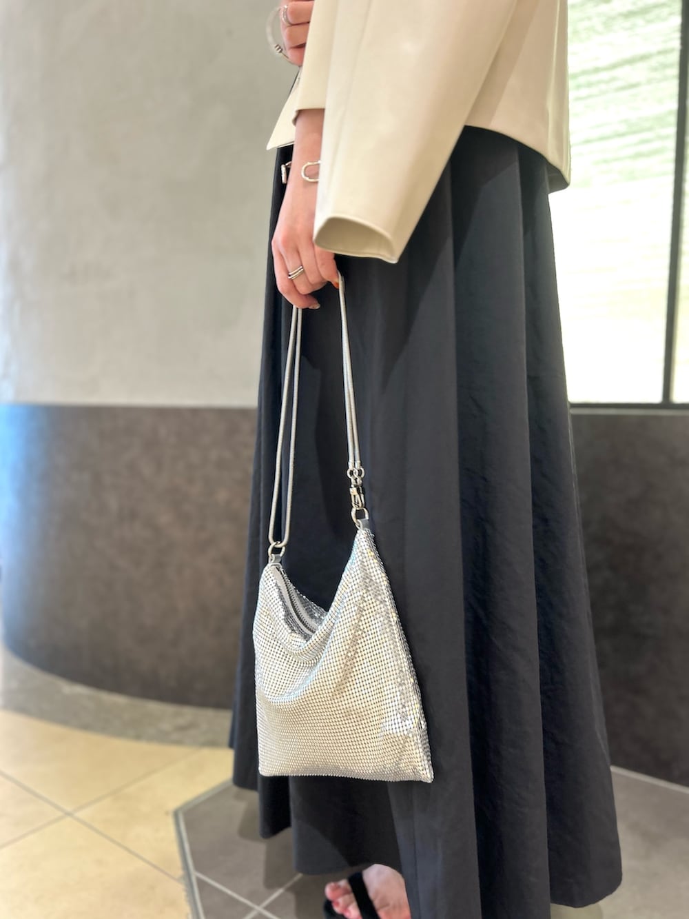 ベージュ系のブルゾン、レッド系のTシャツ/カットソー、ブラック系のスカートを着用したレディースの秋コーディネートの9枚目の写真