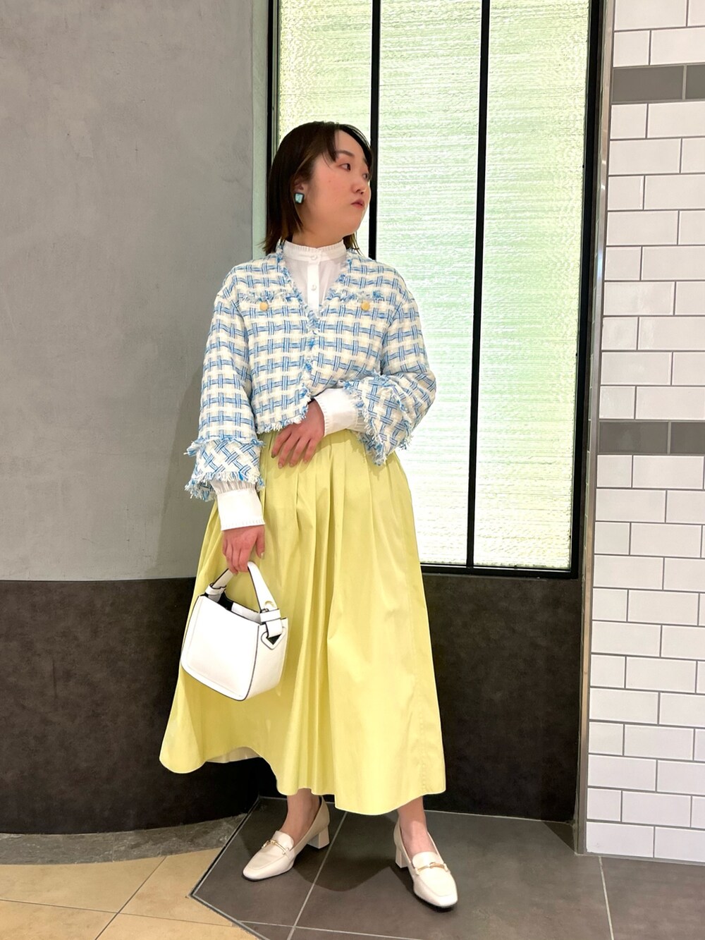 ブルー系のノーカラージャケット、ホワイト系のシャツ/ブラウス、ホワイト系のショルダーバッグを着用したレディースの冬コーディネートの9枚目の写真