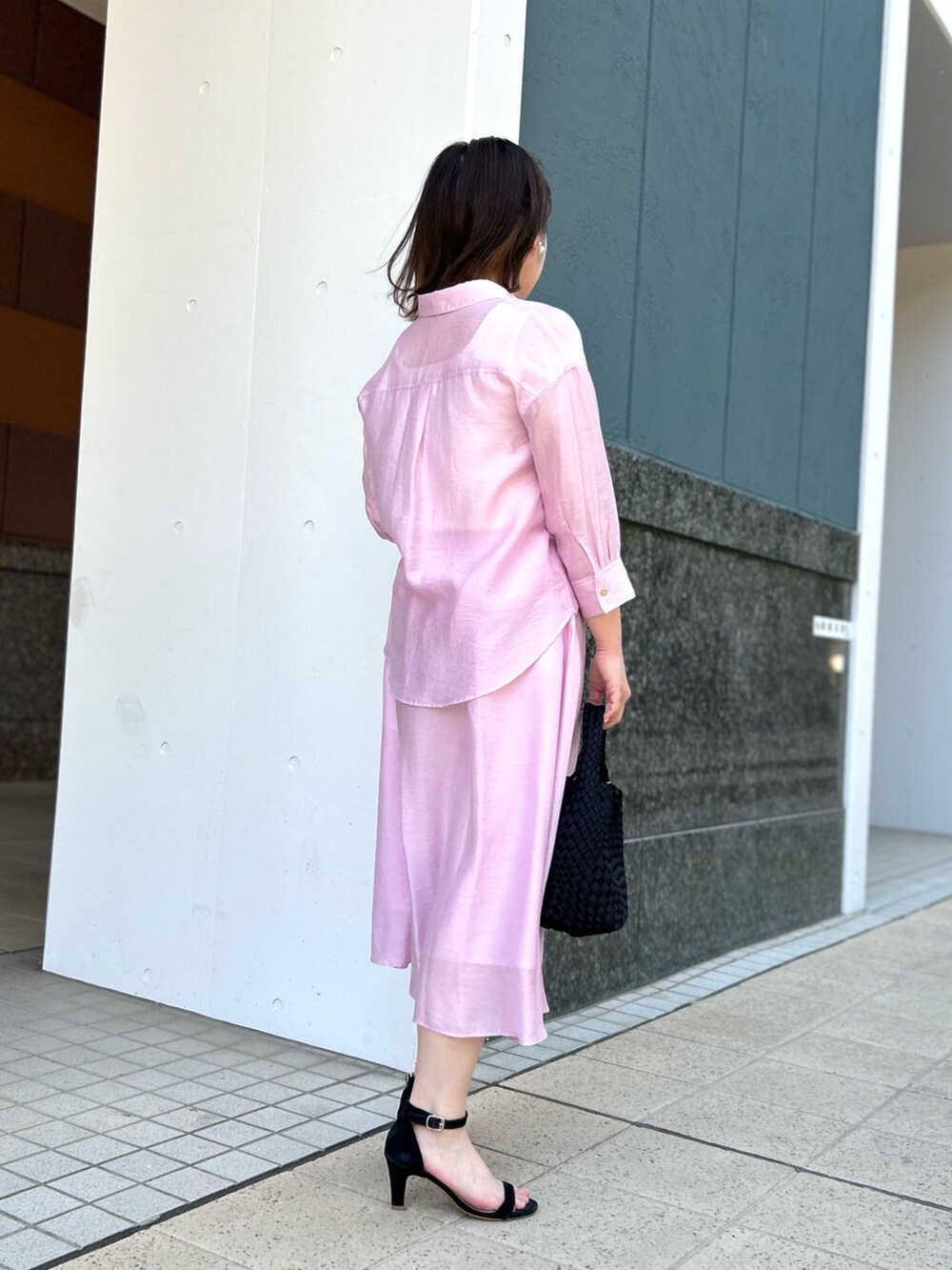 ピンク系のシャツ/ブラウス、ピンク系のスカート、ブラック系のショルダーバッグを着用したレディースの春コーディネートの3枚目の写真