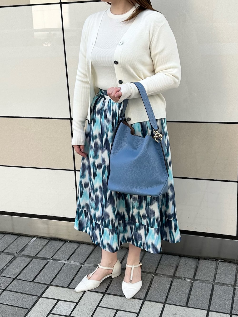 ホワイト系のカーディガン/ボレロ、ホワイト系のニット/セーター、ブルー系のスカートを着用したレディースの秋コーディネートの9枚目の写真