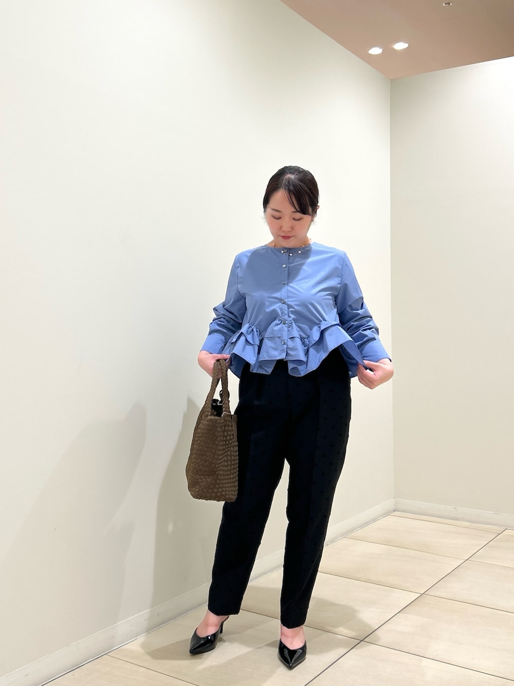 ブルー系のシャツ/ブラウス、ブラック系のその他パンツ、ブラウン系のトートバッグを着用したレディースの秋コーディネートの5枚目の写真