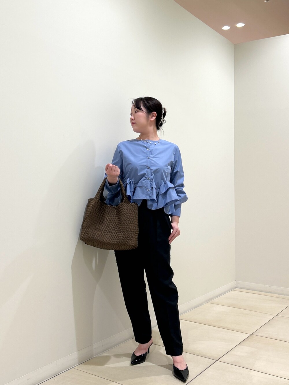 ブルー系のシャツ/ブラウス、ブラック系のその他パンツ、ブラウン系のトートバッグを着用したレディースの秋コーディネートの6枚目の写真