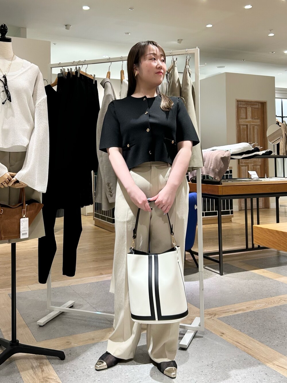 ブラック系のノーカラージャケット、ベージュ系のその他パンツ、ホワイト系のショルダーバッグを着用したレディースの夏コーディネートの9枚目の写真